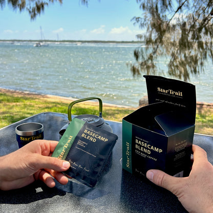 Star Trail coffee basecamp blend open box to see what's inside  by a lakeside setting