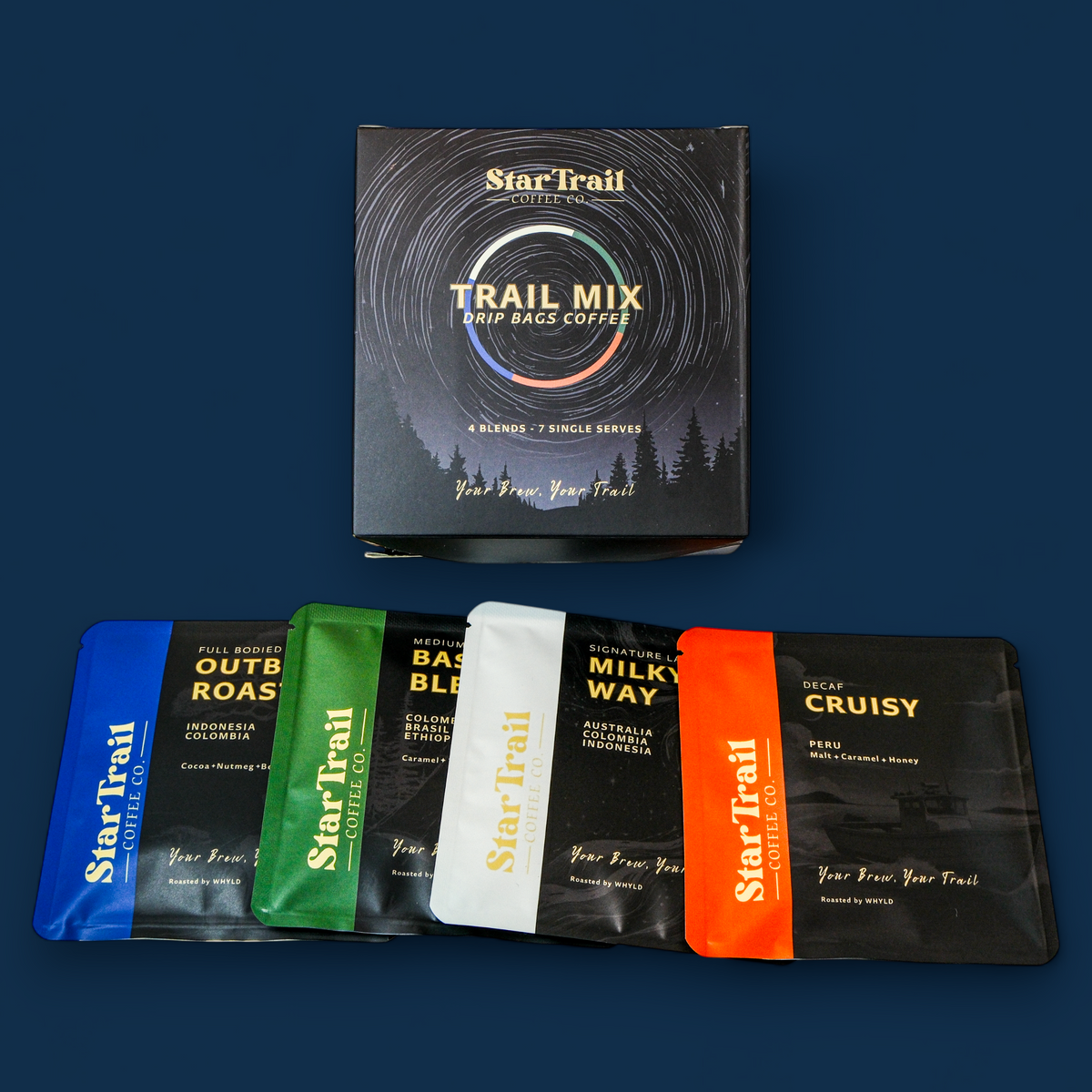 Star Trail Trail Mix box set with five individual flavor sachets displayed in front of the main box on a dark blue background. The box is black with a vinyl record design and the text 'Star Trail Trail Mix'.