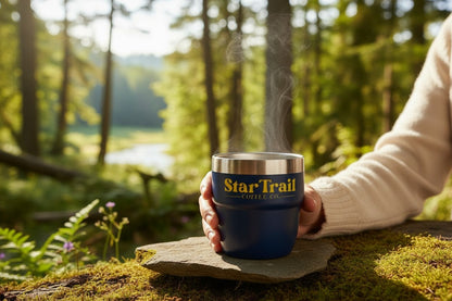 Person holding a 'Star Trail' mug with steam in a forest setting