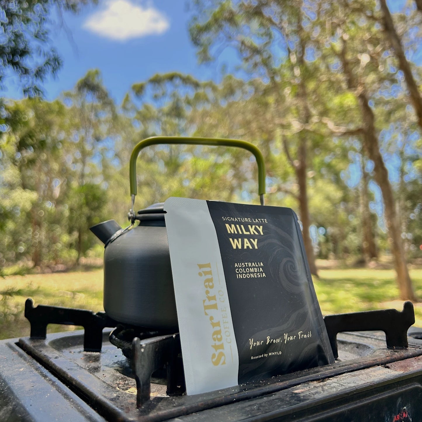 Black teapot with a startrail coffee drip bag  'Milky Way' Latte on a camping stove 