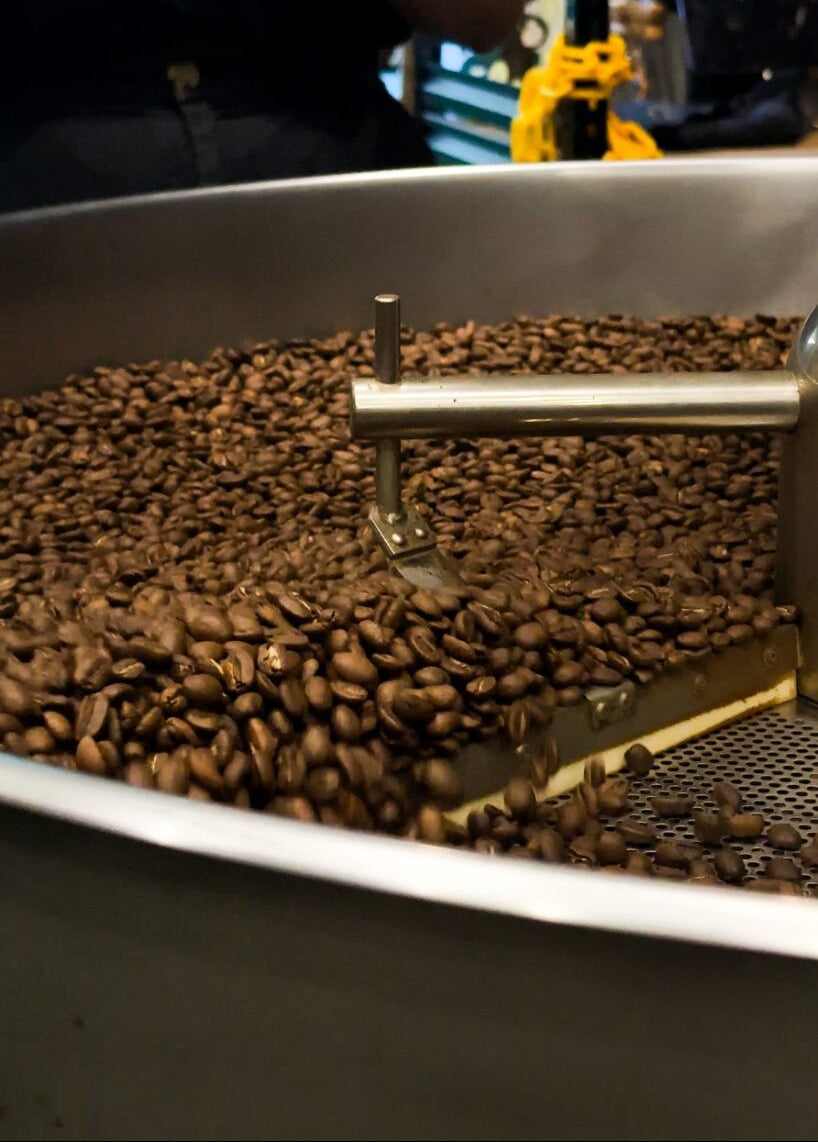 Coffee grinder with coffee beans inside, blurred background
